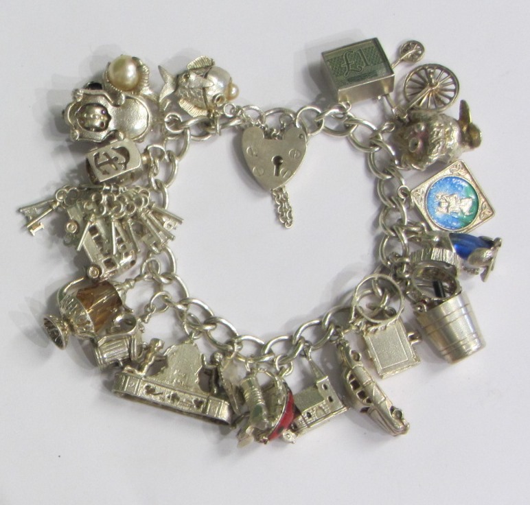 Appraisal: A silver curb link charm bracelet with a silver heart