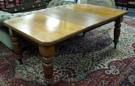 Appraisal: An Edwardian oak dining table the canted top above fluted