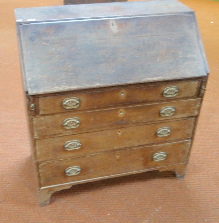 Appraisal: A George III oak bureau with fall flap resting on