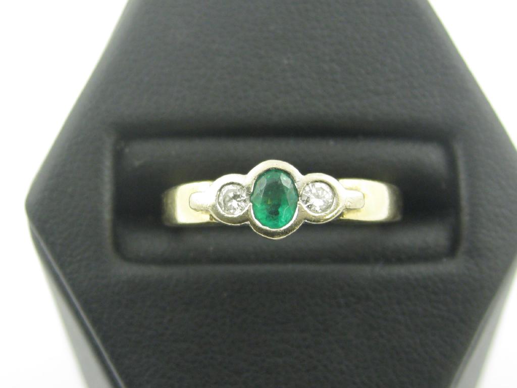 Appraisal: An Emerald and Diamond three stone Ring the central oval-cut