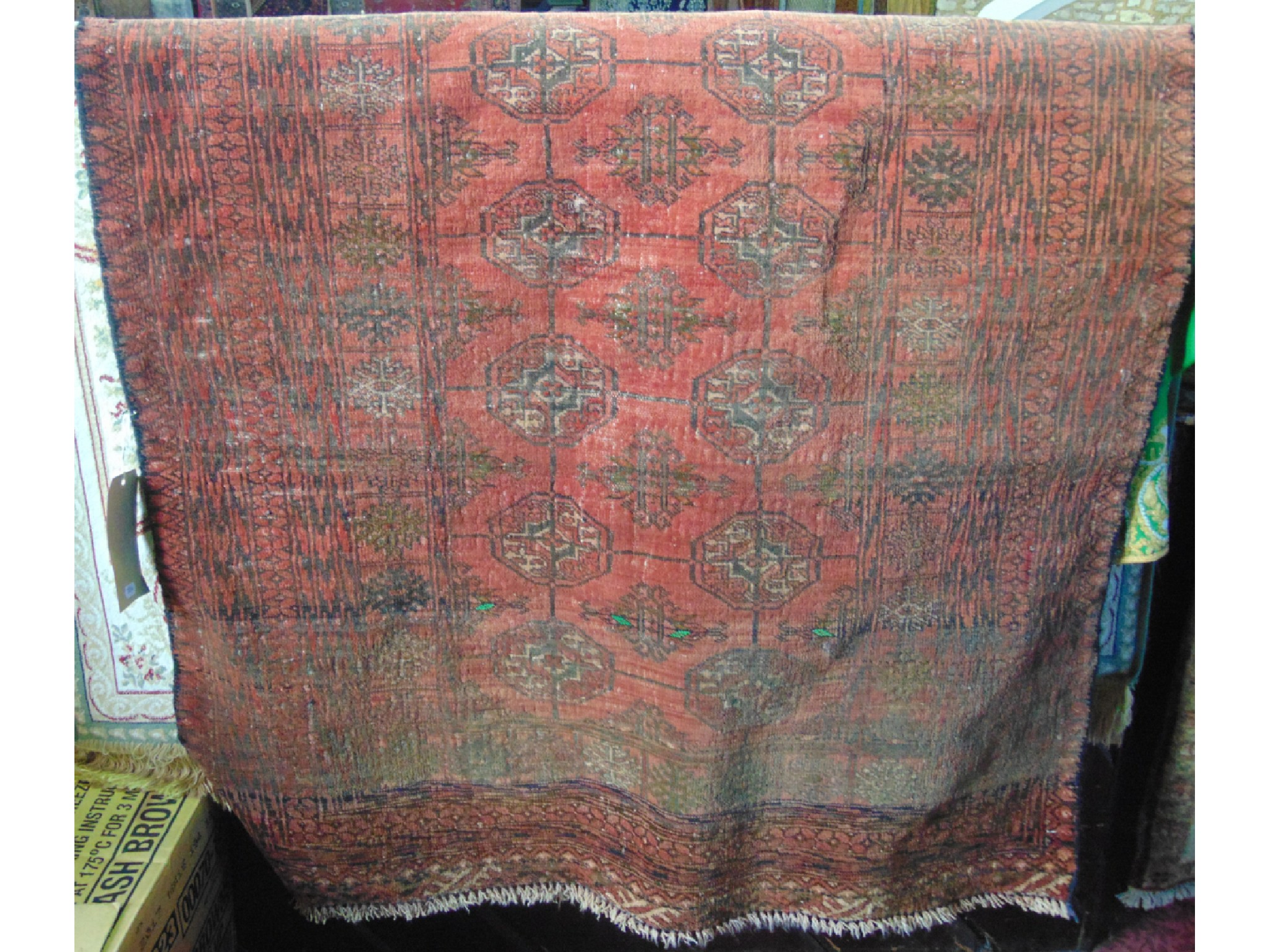 Appraisal: An old eastern woven wool rug with red ground interspersed