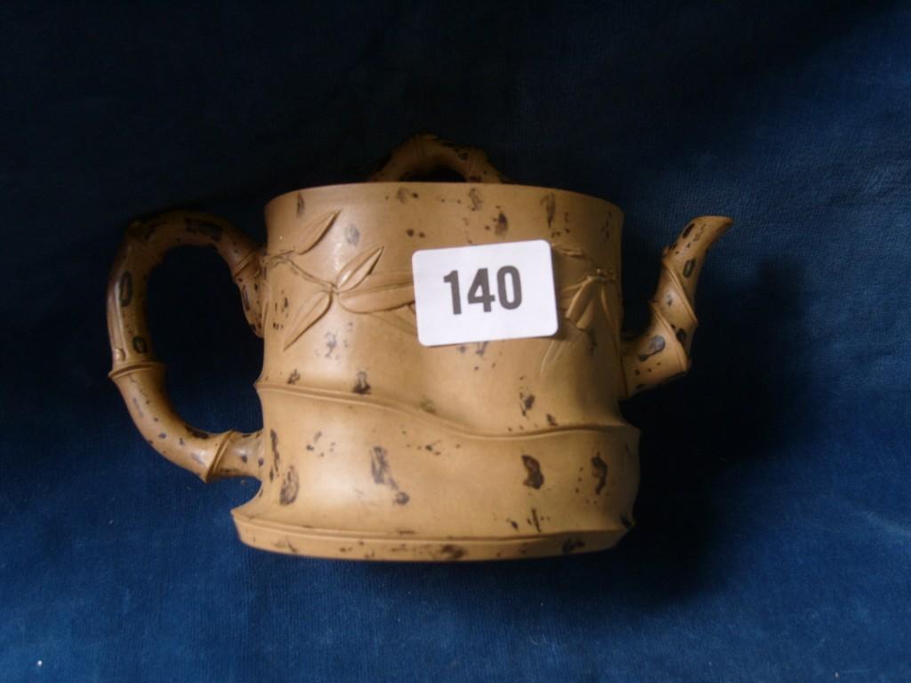 Appraisal: An oriental pottery teapot modelled in buff coloured clay with