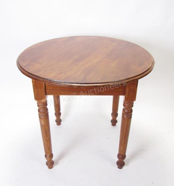 Appraisal: An antique round pine table with turned legs diameter