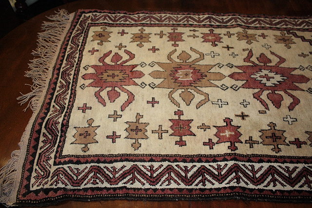 Appraisal: A PAKISTAN IVORY GROUND SMALL RUG with stylised flower head