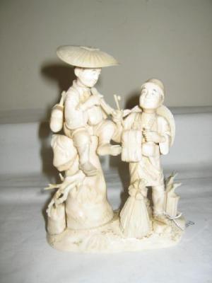 Appraisal: A CARVED IVORY OKIMONO modelled as two men smoking pipes