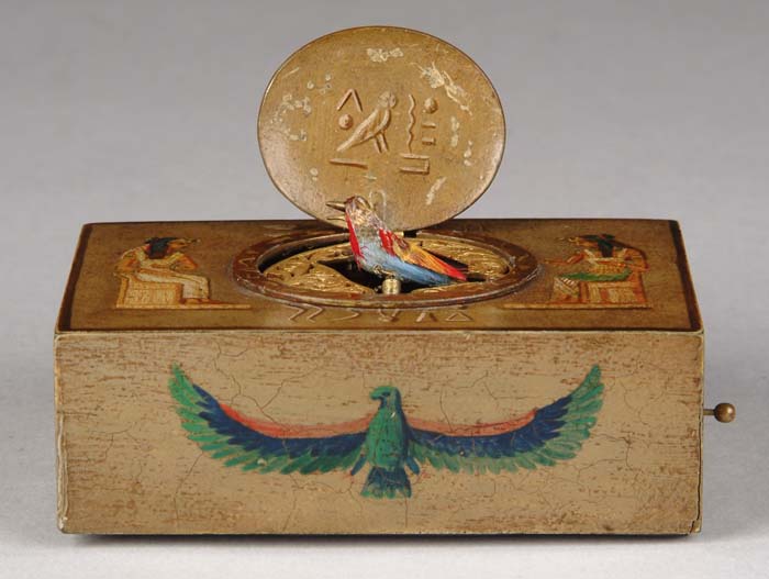 Appraisal: CASED BIRD MUSIC BOX IN EGYPTIAN MOTIF Metal rectangular box