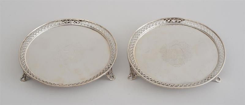 Appraisal: PAIR OF GEORGE III ARMORIAL SILVER TRIPOD WAITERS John Carter