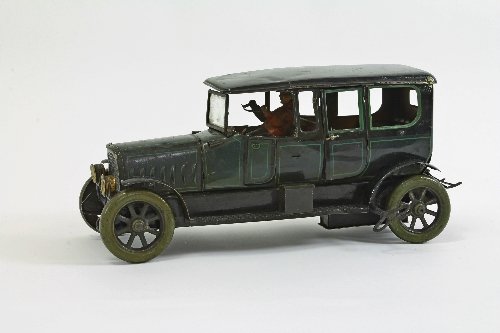 Appraisal: A clockwork tinplate car with opening doors luggage rack and