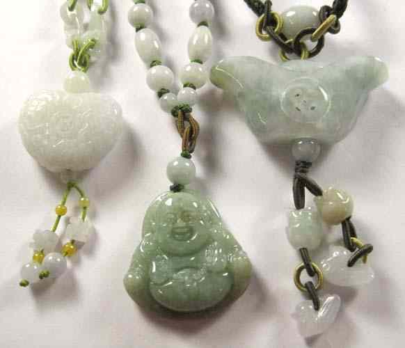 Appraisal: THREE CHINESE CARVED JADE PENDANT NECKLACES each suspended on woven