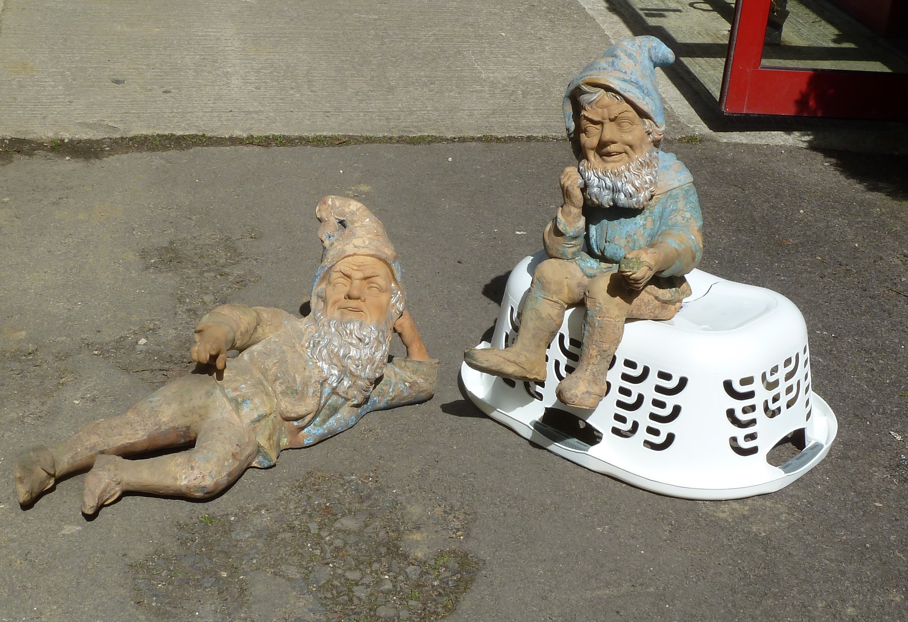 Appraisal: Two large pottery garden gnomes one modelled seated with a