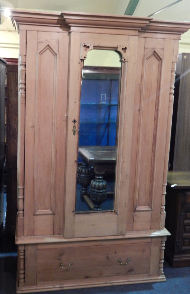 Appraisal: A pine bowfront wardrobe with a single mirrored door above