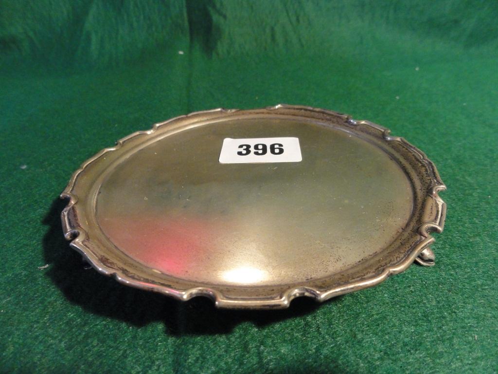 Appraisal: A silver card tray with scrolled edge raised on pad