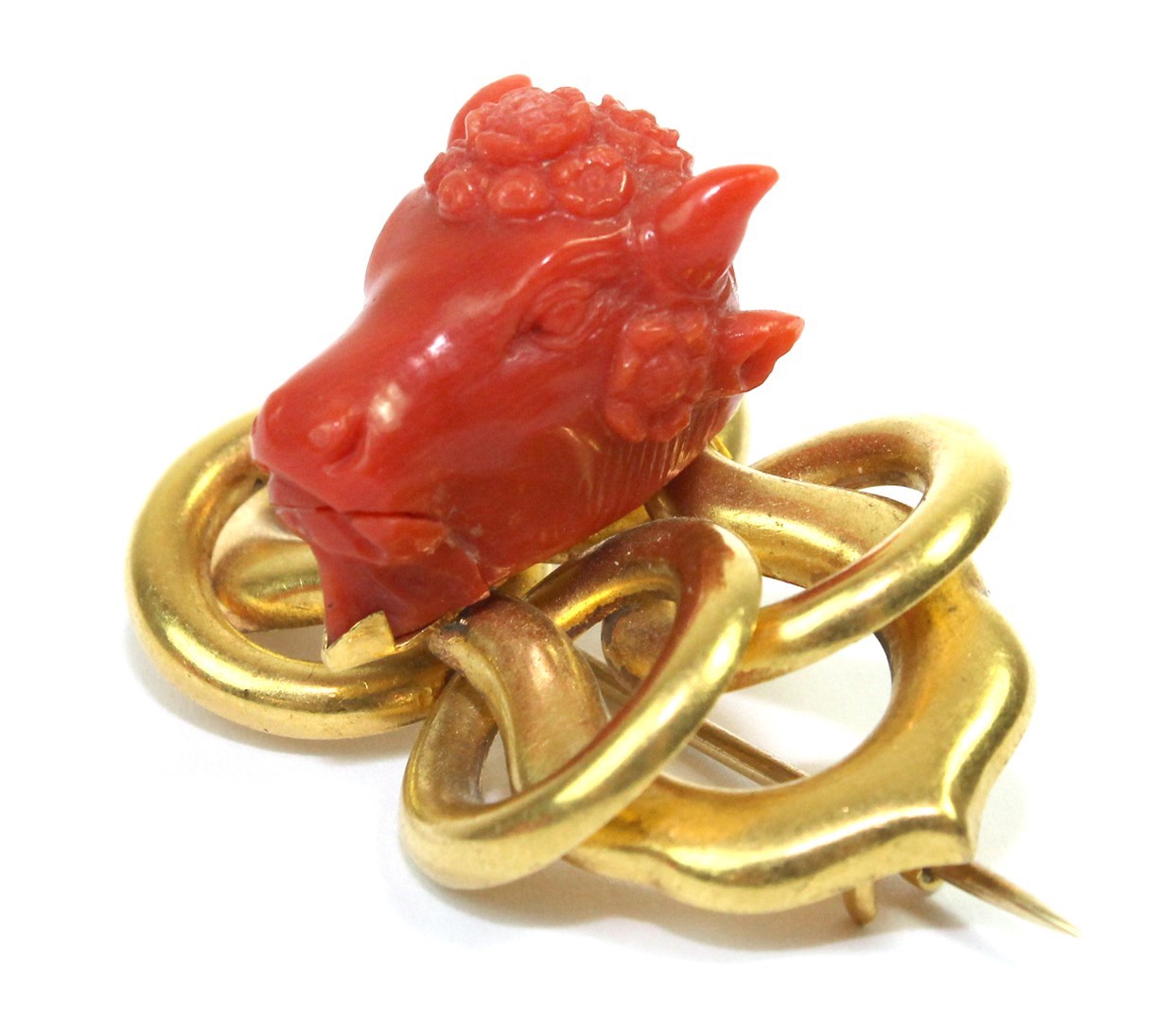 Appraisal: A gold and carved coral brooch the centre mounted with