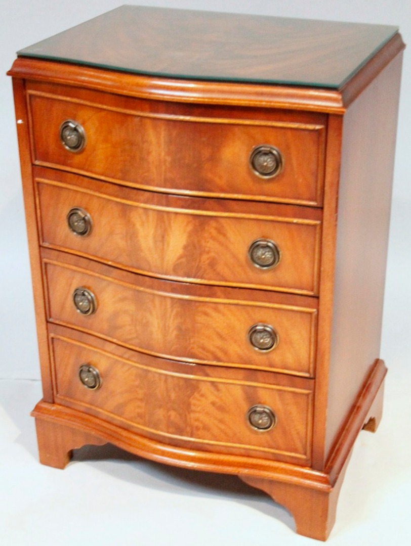 Appraisal: A modern flamed mahogany finish serpentine chest of four long