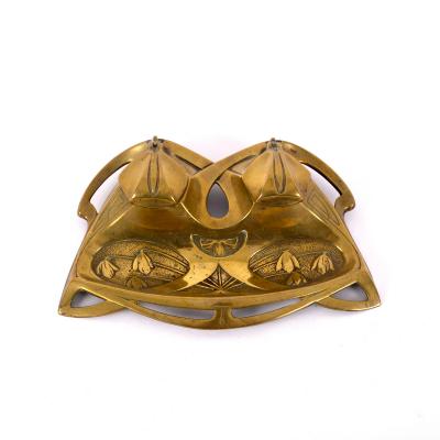 Appraisal: A brass inkwell in the Jugendstil style embossed snowdrops and