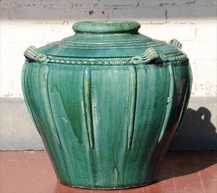 Appraisal: GREEN GLAZED POTTERY JAR The ovoid body decorated with ribs