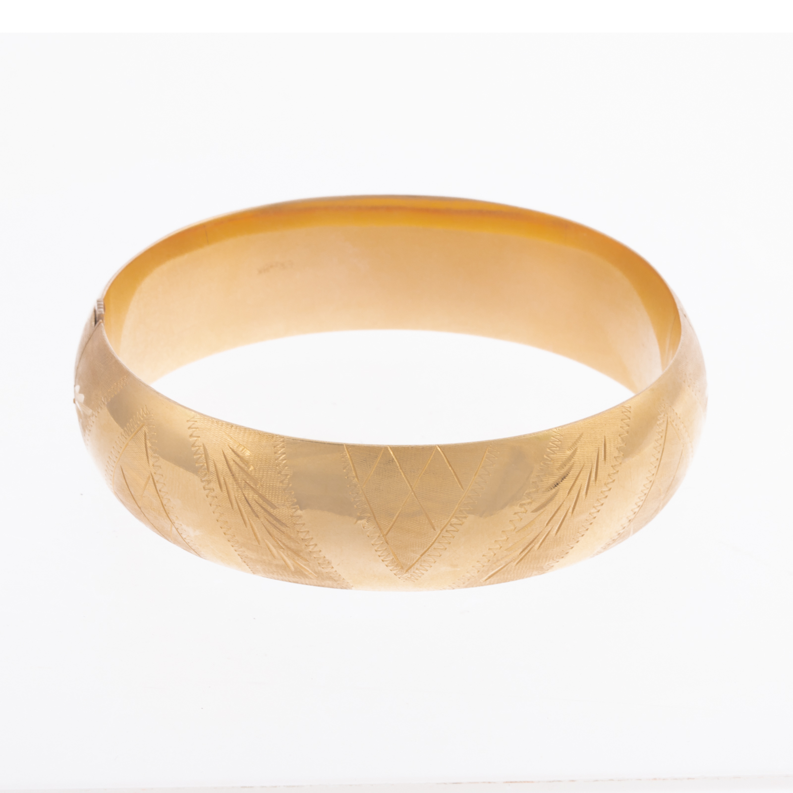 Appraisal: AN ENGRAVED BANGLE IN K K yellow gold hinged bangle