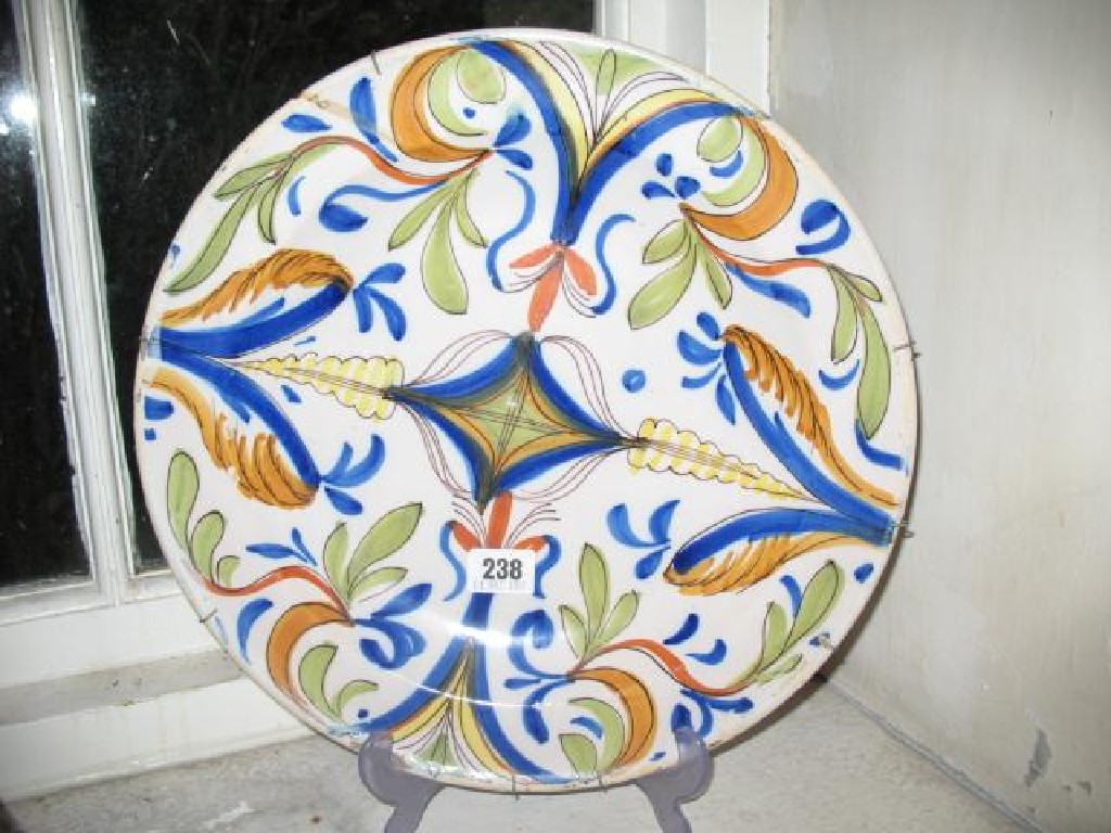 Appraisal: A CONTINENTAL TIN GLAZED CHARGER decorated in polychrome with stylised