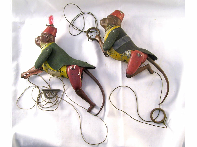 Appraisal: Tin Litho Mechanical Monkeys Two string toys with finger rings