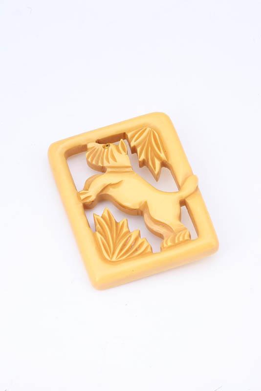 Appraisal: CARVED BAKELITE PIN Yellow with a dog in the center