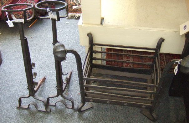 Appraisal: A wrought iron fire basket with segmental round finials and