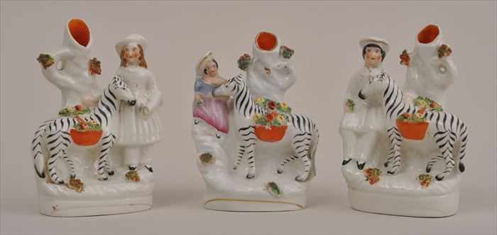 Appraisal: THREE STAFFORDSHIRE ZEBRA SPILL VASES Each beast carrying flower-filled basket