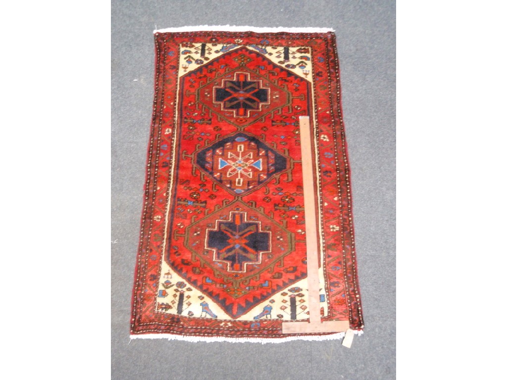 Appraisal: A red ground tri-medallion rug ' x '