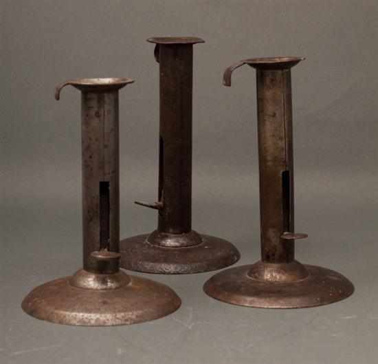 Appraisal: Set of three American sheet iron hog scraper candlesticks mid-