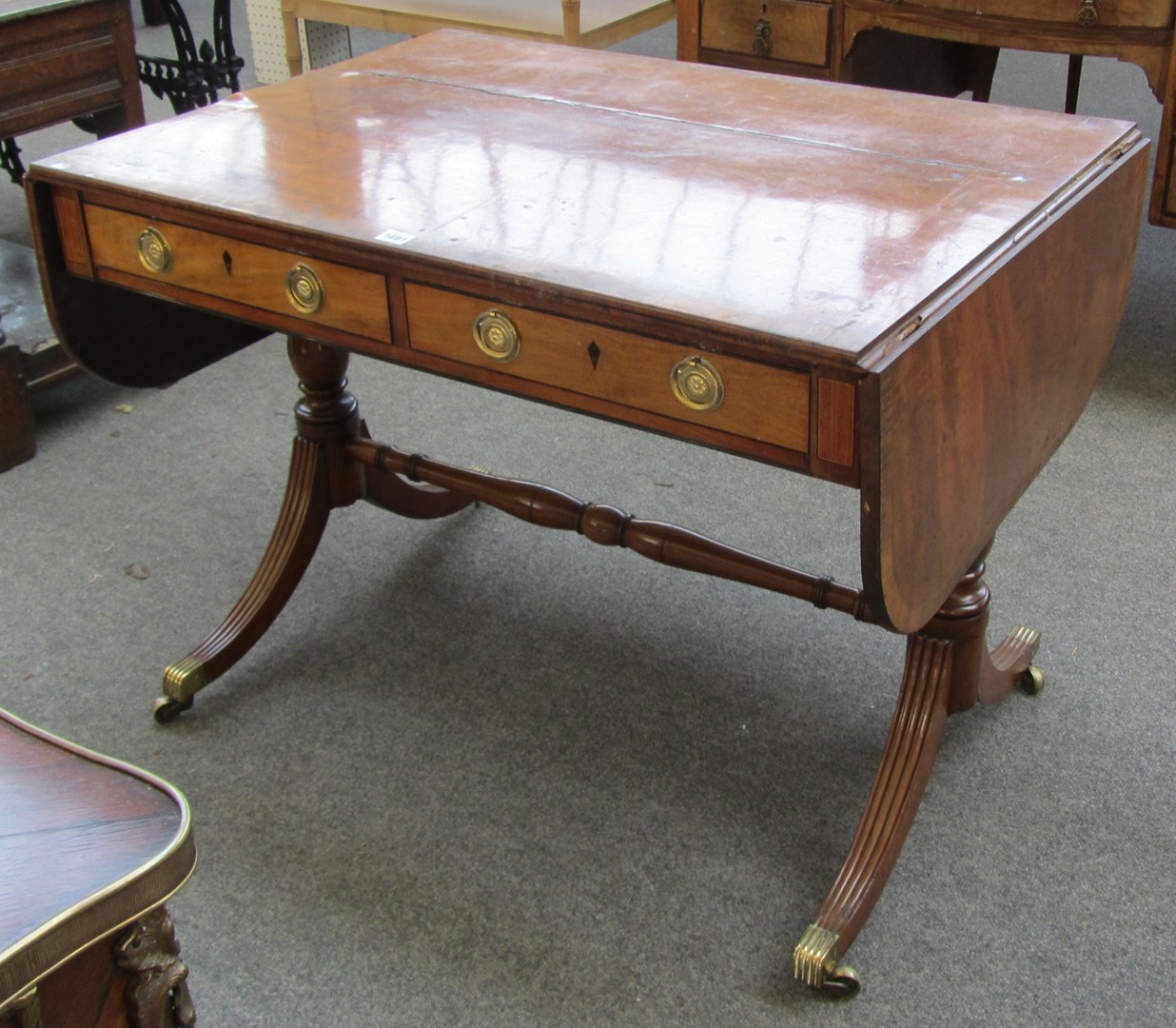 Appraisal: A Regency mahogany and rosewood crossbanded sofa table the rounded