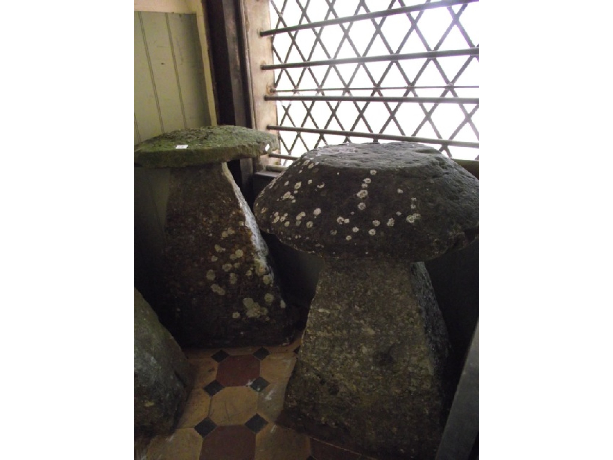 Appraisal: Two weathered natural stone staddle stones with tapered bases beneath