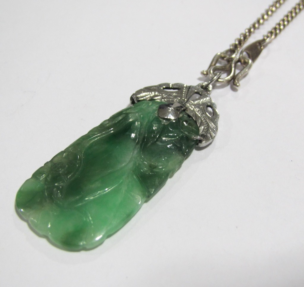 Appraisal: Chinese jade pendant carved with foliate detail in white metal