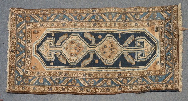 Appraisal: A KURDISH BLUE GROUND RUG with a central inter-linked medallion