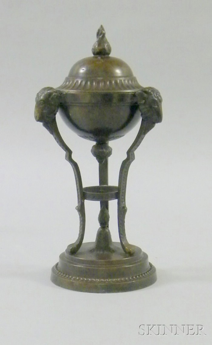 Appraisal: Neoclassical Bronze Perfume ram's head stand holding an urn with