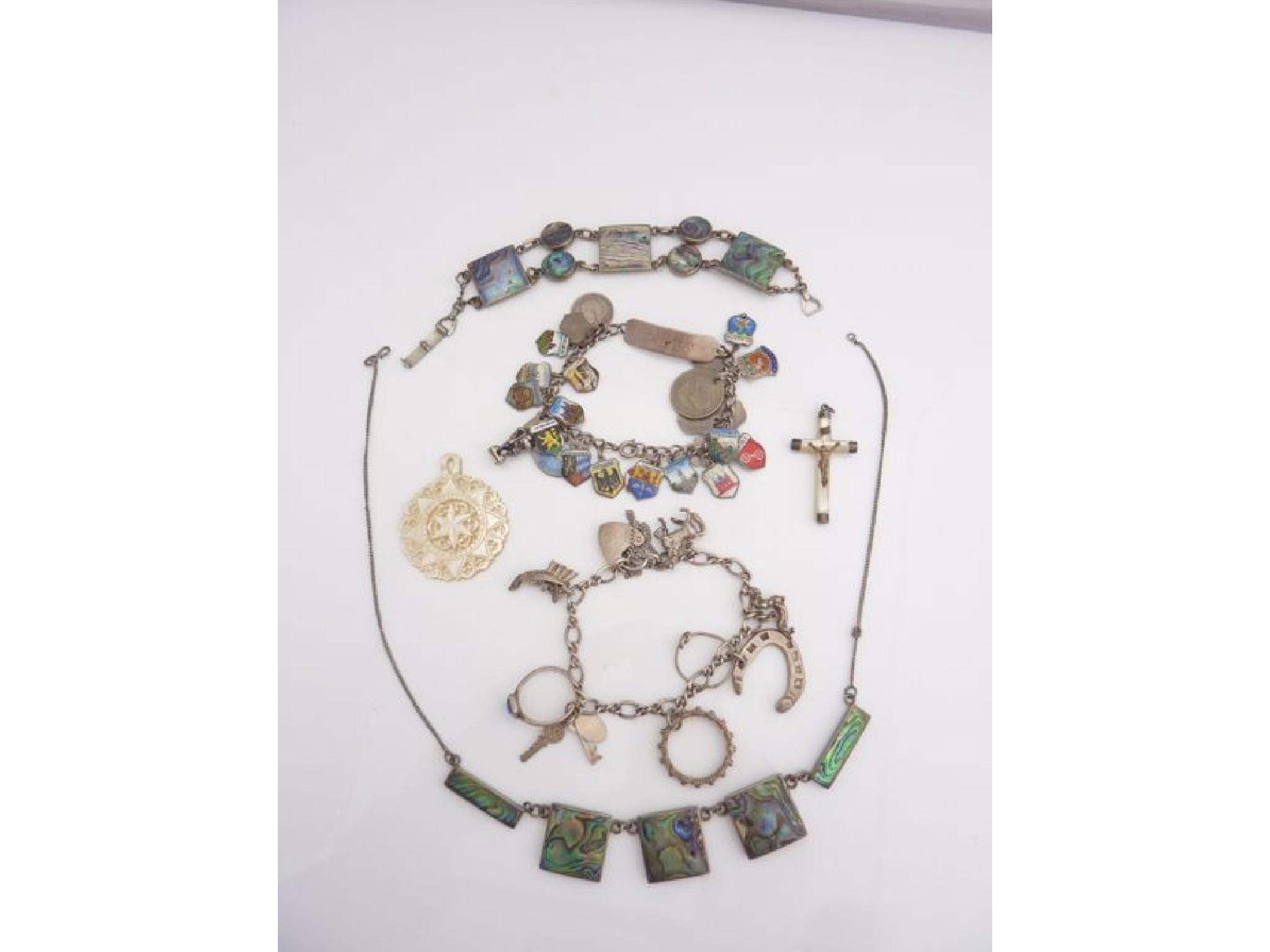 Appraisal: A silver charm bracelet hung with various shield shaped enamelled