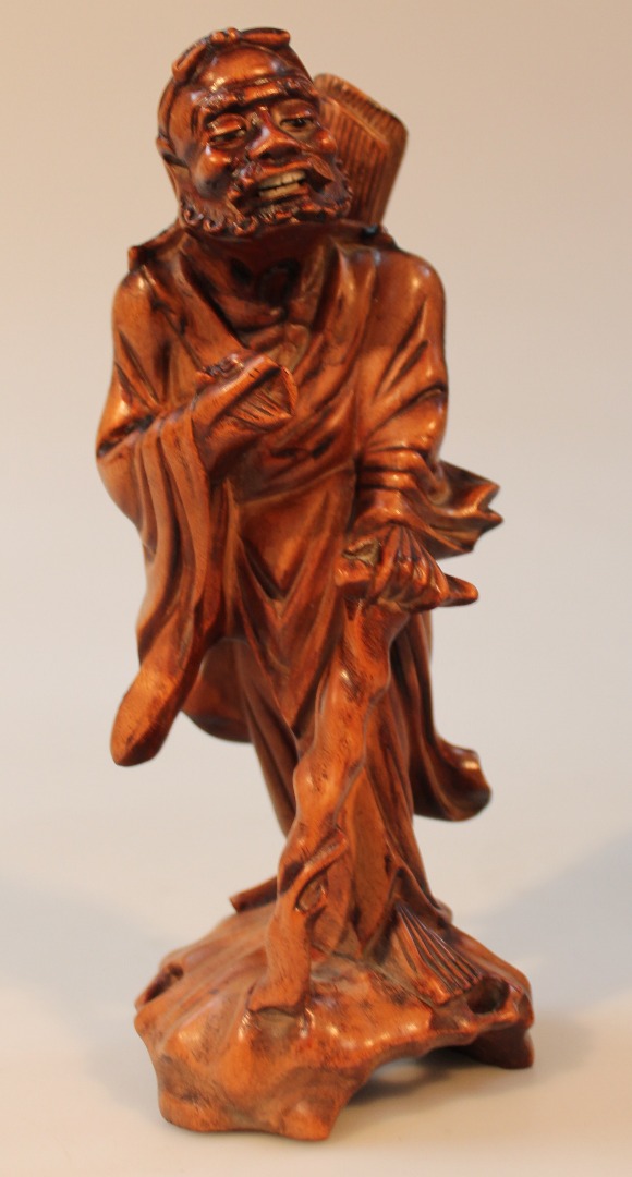 Appraisal: A thC soft wood carving of an oriental figure wearing