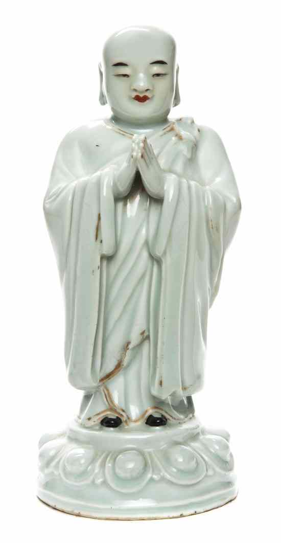 Appraisal: A Chinese Porcelain Figure of a Buddhist Disciple depicted standing