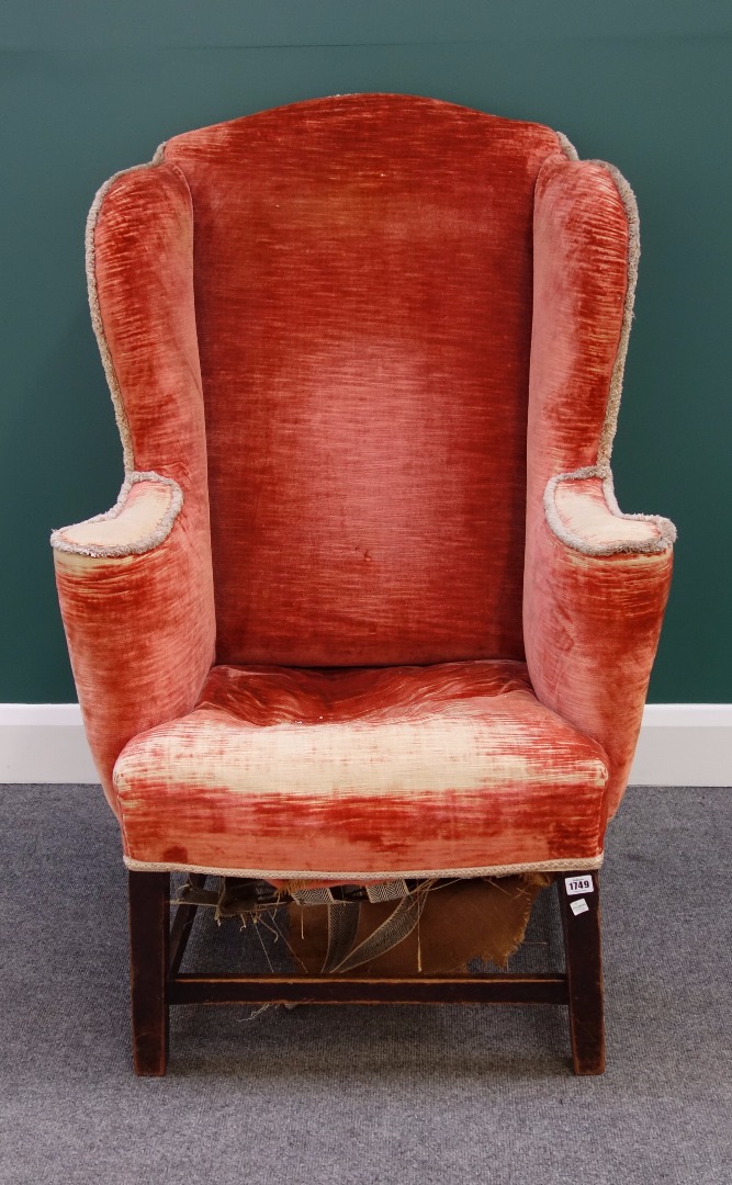 Appraisal: A th century wingback armchair on tapering square mahogany supports