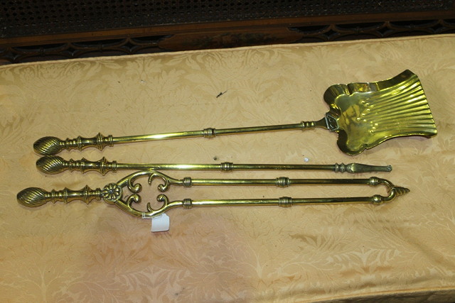 Appraisal: A SET OF THREE BRASS FIRE IRONS each with wrythen