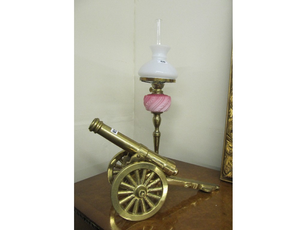 Appraisal: Brass oil lamp with pink opaque glass reservoir and a