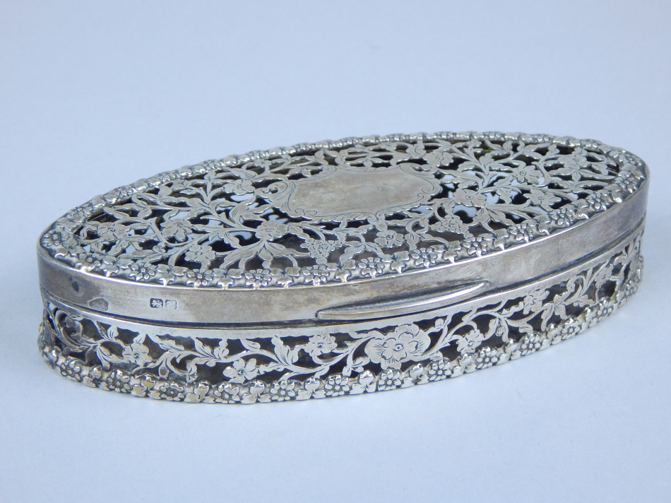 Appraisal: An Edwardian pierced silver oval trinket box and cover decorated