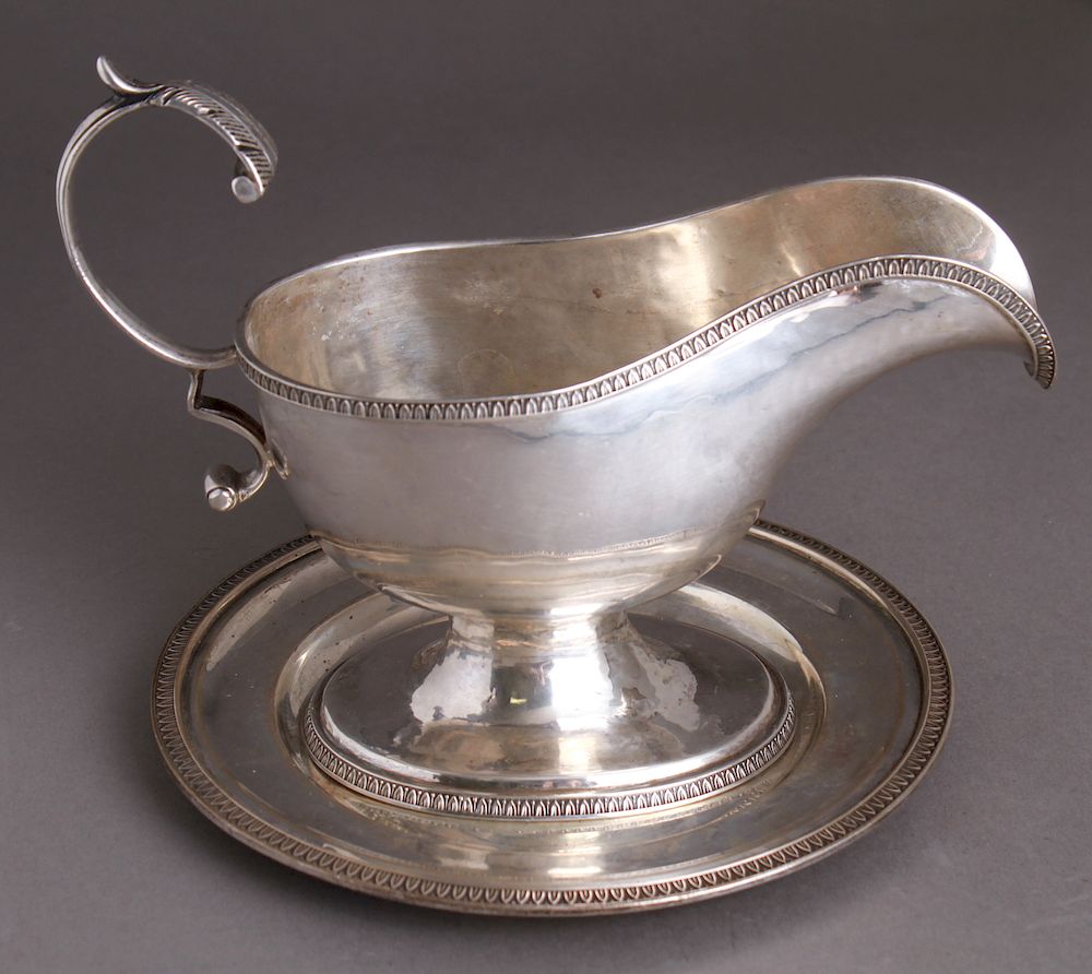 Appraisal: Neoclassical Continental Silver Sauceboat Plate Neoclassical continental silver gravy sauce