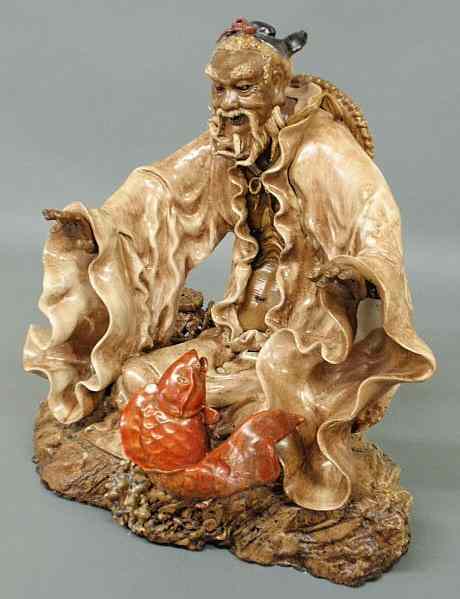 Appraisal: Chinese glazed pottery figure of a man with a koi