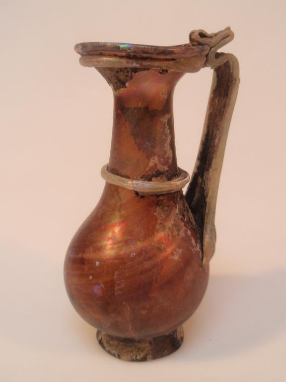 Appraisal: A late Roman streaky purple glass jug the flaring mouth