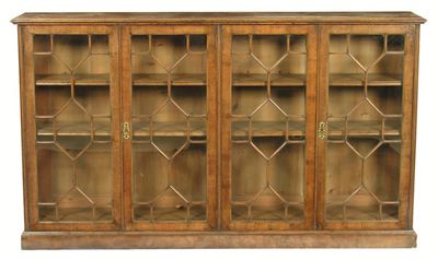 Appraisal: A walnut veneered bookcase the twin quartered burr top with