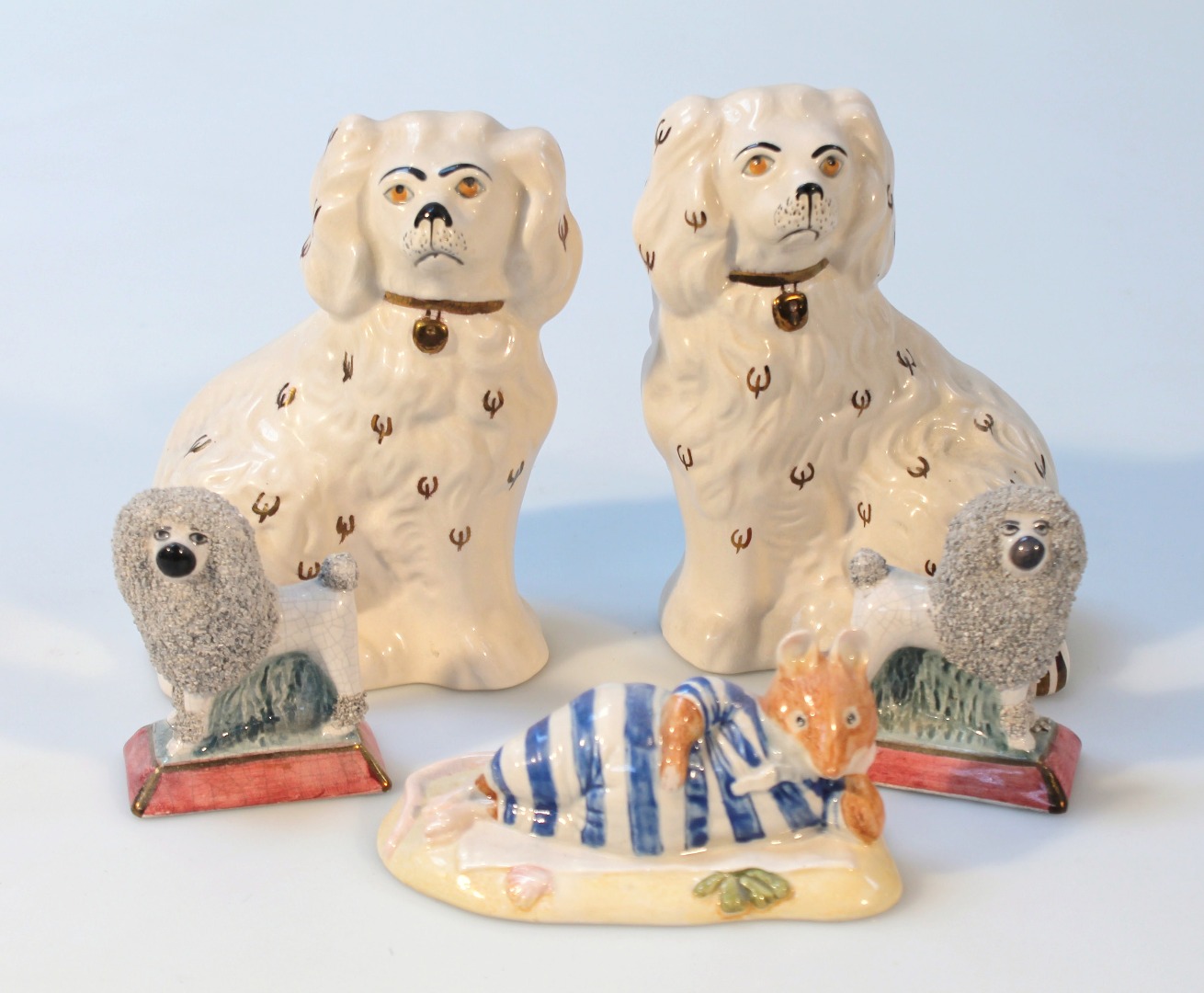 Appraisal: A pair of Staffordshire figures of poodles each standing on