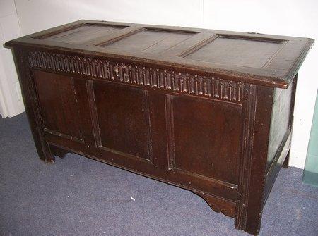 Appraisal: An oak chest with triple hinged cover and carved arches