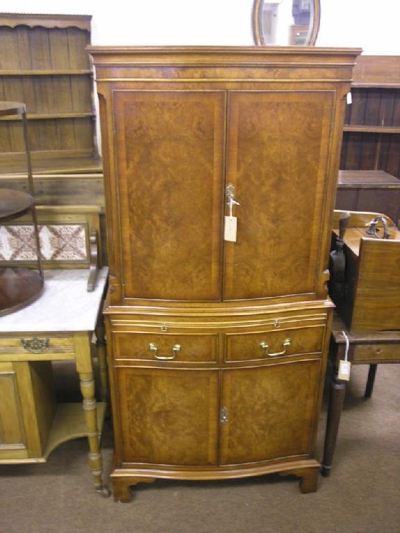 Appraisal: A reproduction burr walnut veneered cocktail cabinet serpentine fronted with