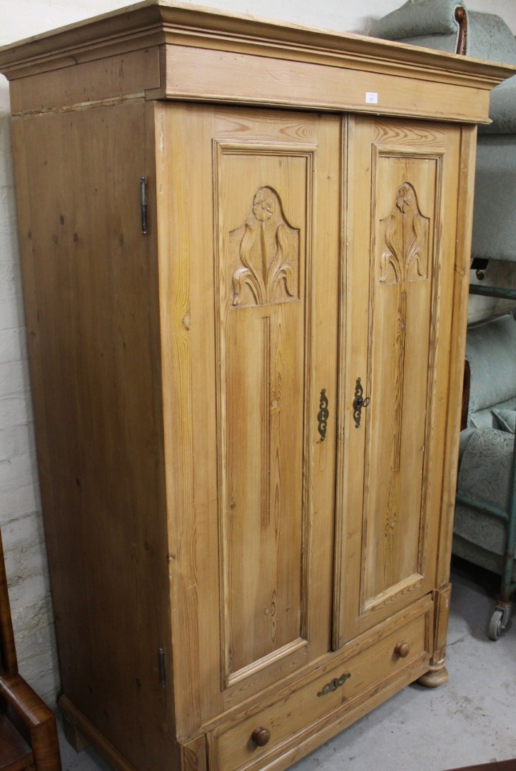 Appraisal: A stripped and lightly polished reconstituted pine double drawer armoire