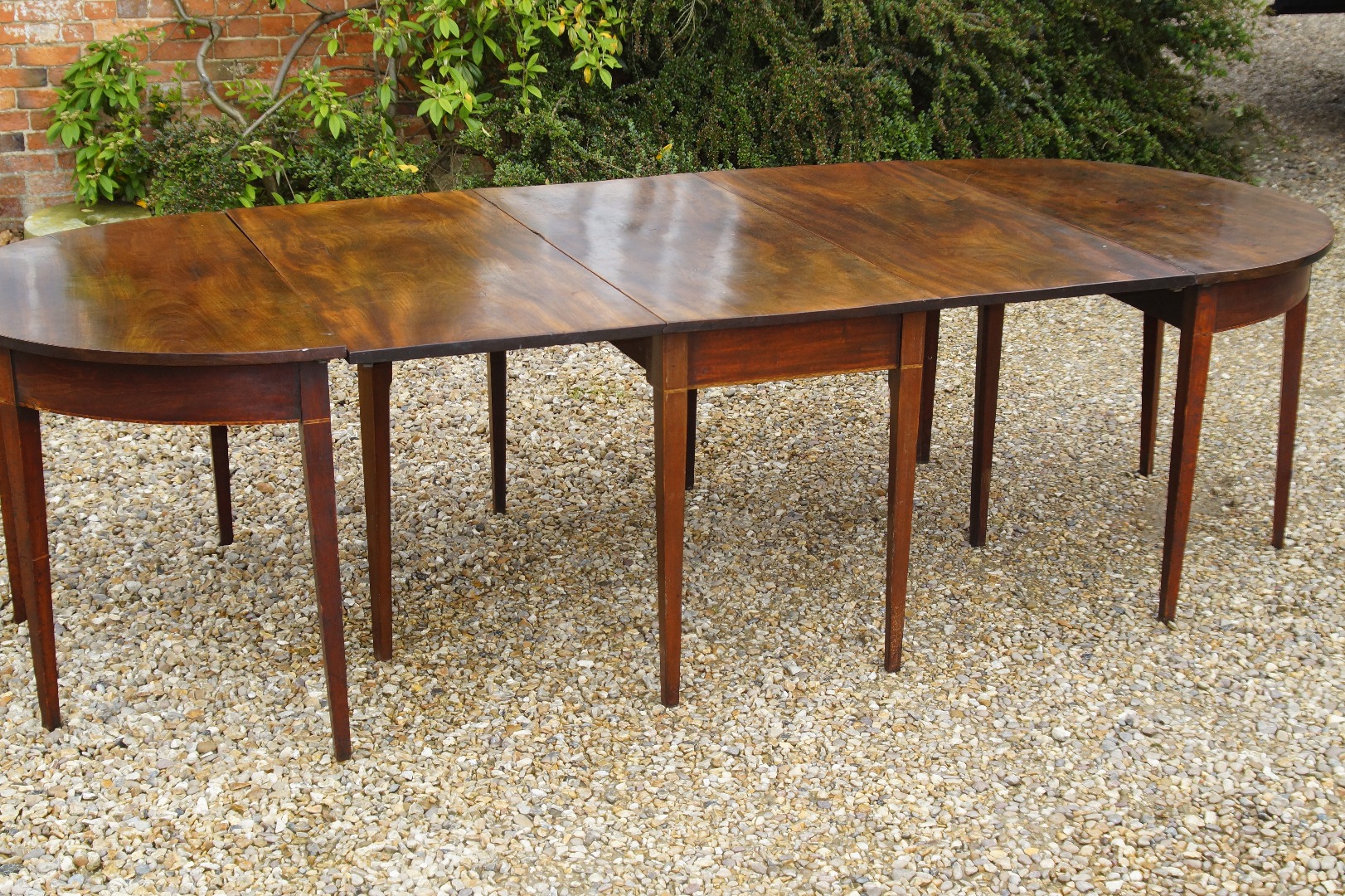 Appraisal: A George III mahogany dining table with two demi-lune ends