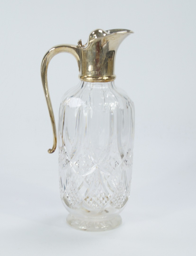 Appraisal: A cut crystal claret jug with silver handle and mounts